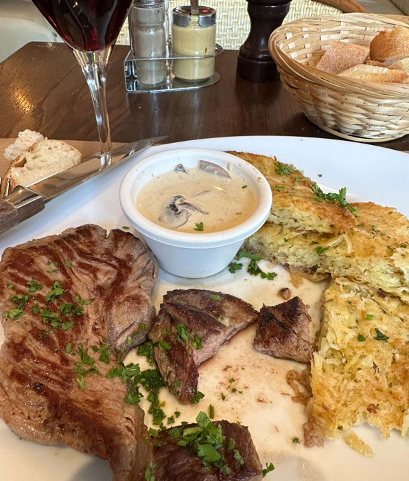 A plate of food in a Paris cafe, a veal filet with a light cream and mushroom sauce.
